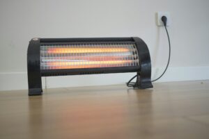 Modern electric infrared heater in living room, closeup