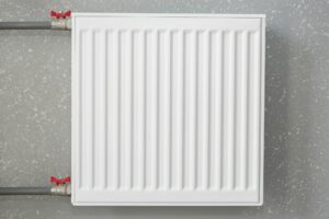 White battery on the wall. Iron radiator. Modern heating system.